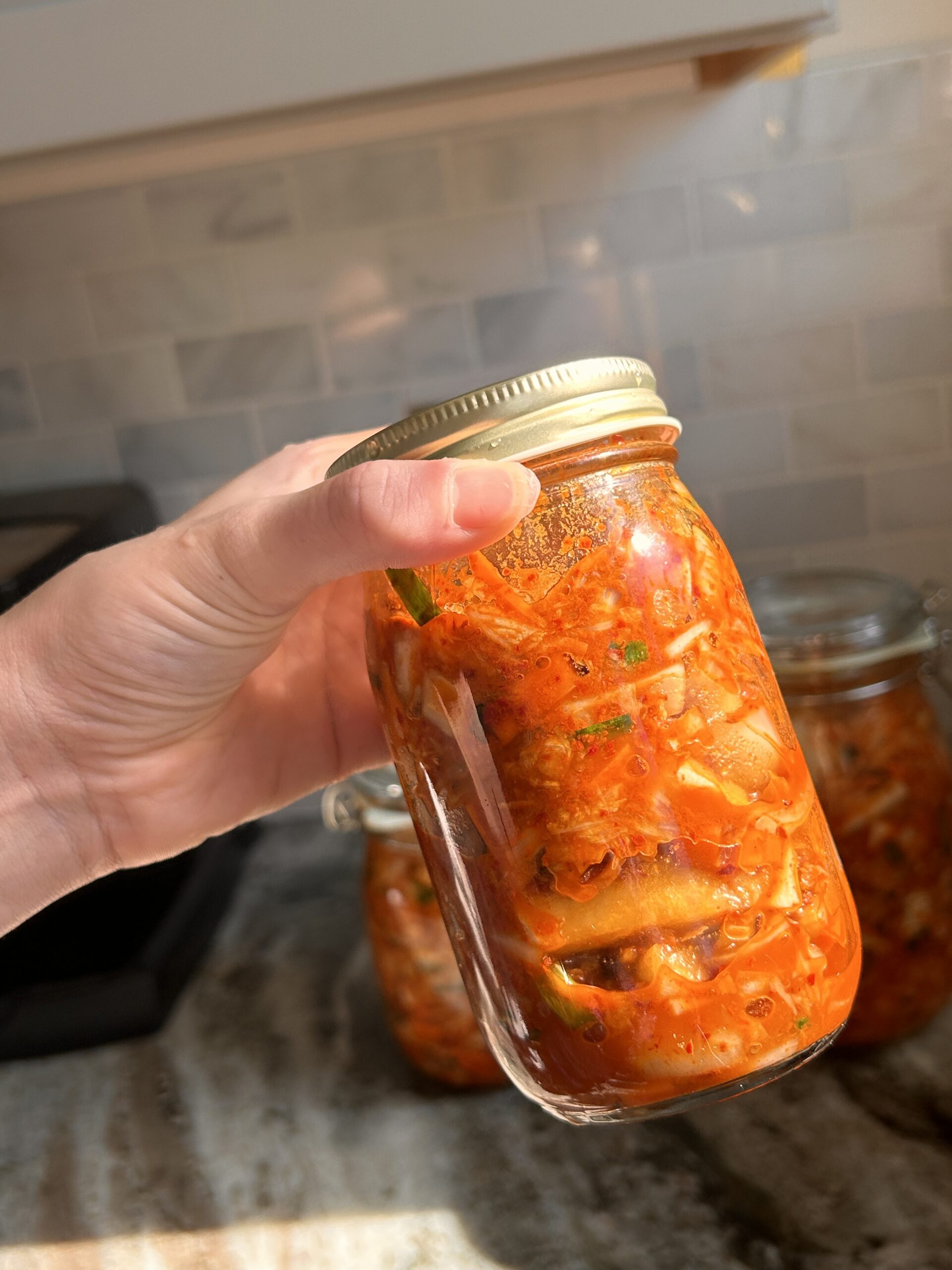 A collection of jars filled with homemade kimchi, ready for fermentation and storage.