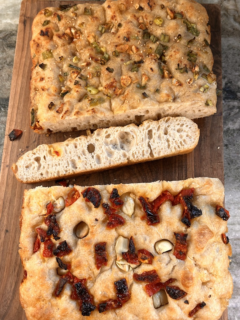 A view of the sundried tomato and garlic focaccia sliced, ready to serve. A close-up of the airy crumb inside the focaccia, showcasing its fluffy texture.