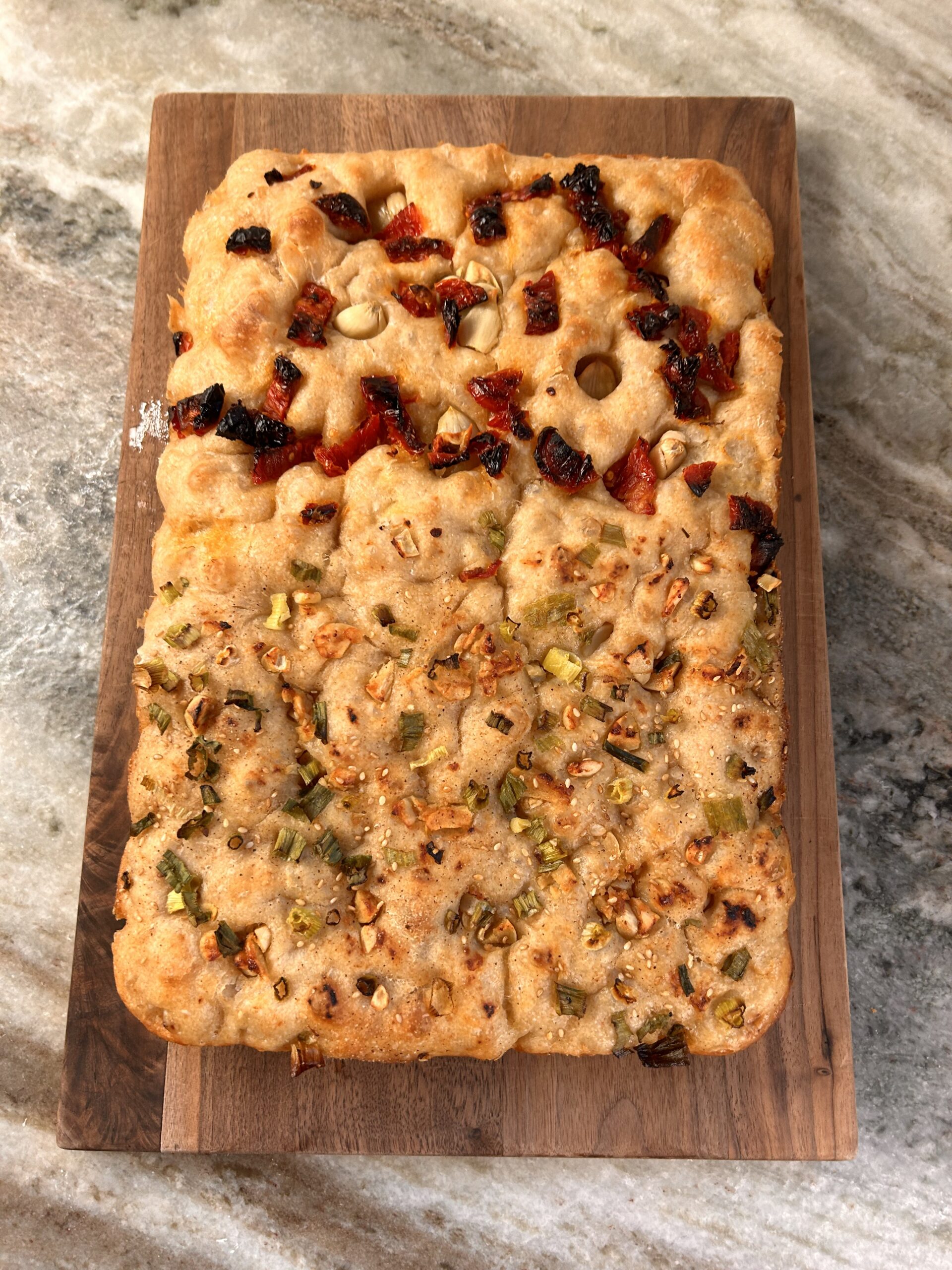 When in doubt, split the dough! 🍅🧄 This sundried tomato and garlic focaccia is proof that simple ingredients can pack bold flavors. Paired with scallions and sesame seeds on the other half, it’s a win-win for bread lovers. Have you ever tried splitting your dough for different toppings? Let’s hear your ideas! #Focaccia #BreadLovers #MediterraneanBaking #HomemadeBread"